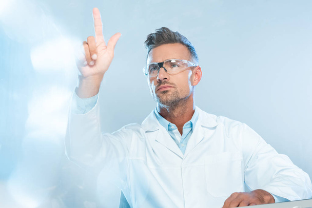 handsome scientist in protective glasses touching something isolated on white, artificial intelligence concept - Foto, Imagen
