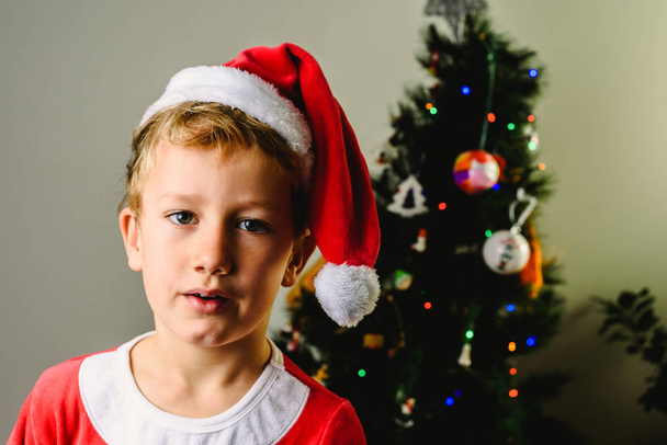 ノエル、ホリデイ ・ コンセプトとして服を着たサンタ クロースの到着を待ってハンサムな子クリスマス - 写真・画像