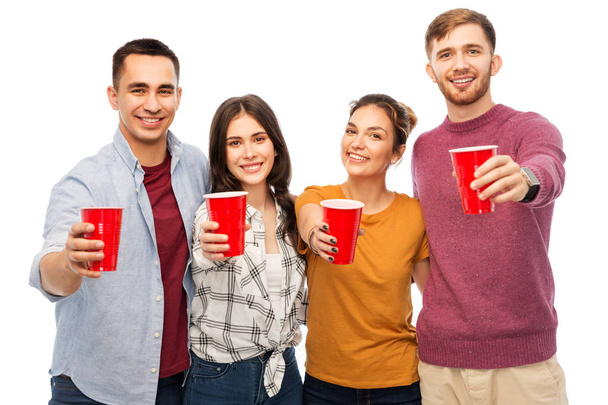 group of smiling friends with drinks in party cups - Фото, изображение