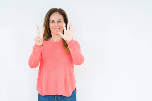 Красива жінка середнього віку над ізольованим тлом, що показує і вказує пальцями номер сім, посміхаючись впевнено і щасливо
. - Фото, зображення