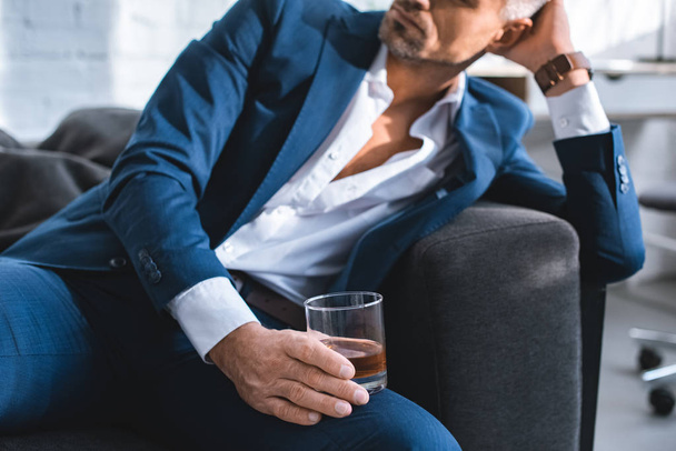 cropped view of businessman holding glass with alcohol drink  - Zdjęcie, obraz
