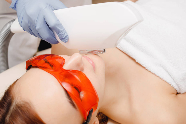 Het wegwerken van gezichtshaar bij vrouwen. Meisje op procedure laser verwijdering. Verzorging en schoonheid - Foto, afbeelding