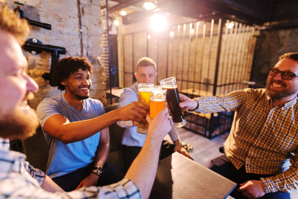 young happy bearded men drinking with beer in pub and having fun - Foto, Bild