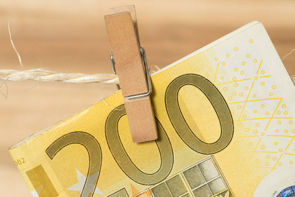 Un billete de 200 euros en un tendedero con pinza de ropa
 - Foto, imagen