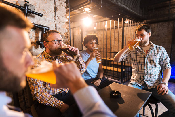 jovens homens barbudos felizes bebendo cerveja no pub
 - Foto, Imagem