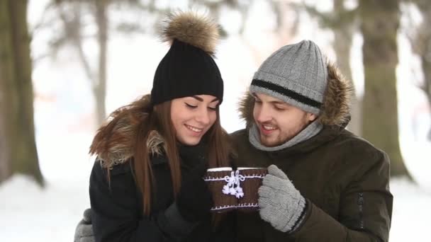 Una pareja feliz pasa tiempo juntos en invierno. Beben té caliente en el parque. Humor de Navidad
 - Imágenes, Vídeo