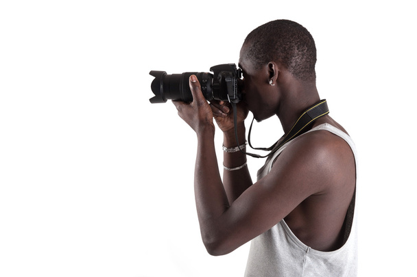 Young african man holding camera over white background. - Fotó, kép