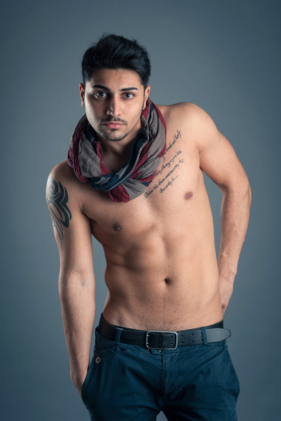 Portrait of confident young man shirtless against dark background. - Foto, Imagen