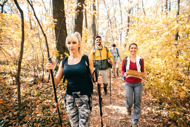 Happy small group of hikers exploring the woods in autumn. - Foto, Bild