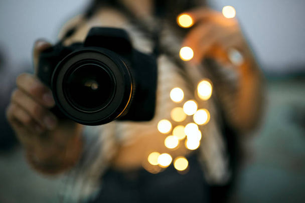 junge Frau mit professioneller digitaler Fotokamera mit Bokeh-Licht - Foto, Bild