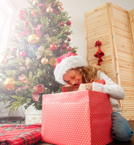 Child with gift near christmas tree - Foto, immagini