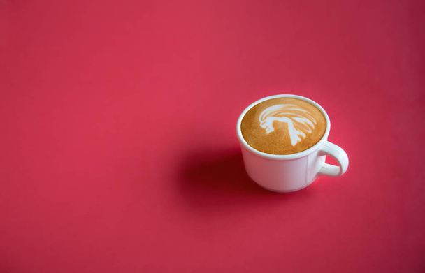 A white cup of hot coffee latte art on red background with copy space or space for text, design for wide banner, poster, postcard, Top view. - Foto, immagini