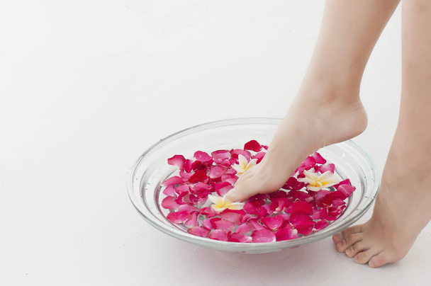 Young Asian woman putting her feet in a bowl of roses, - Fotografie, Obrázek
