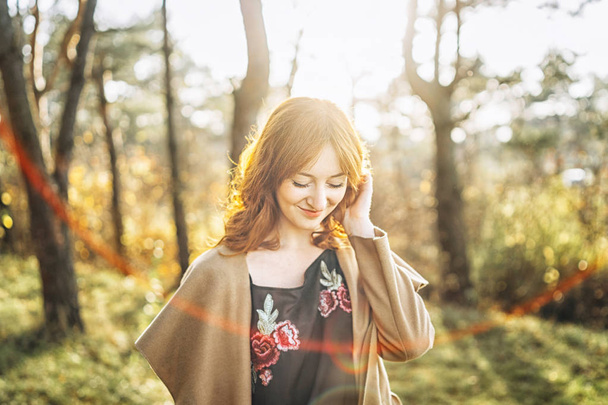 Pretty and happy red hair girl walking in the forest - Fotografie, Obrázek