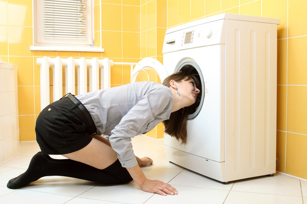 Звичайна проста красива дівчина поклала голову в пральну машину
 - Фото, зображення