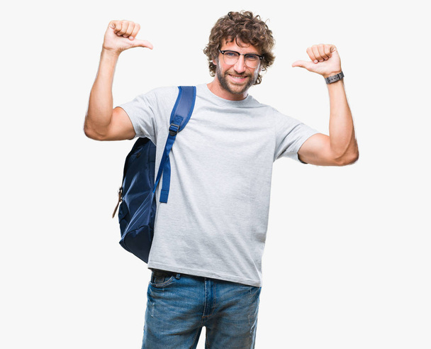 Knappe Spaanse student man met rugzak en glazen op geïsoleerde achtergrond op zoek vertrouwen met glimlach op het gezicht, wijzen zichzelf met de vingers trots en blij. - Foto, afbeelding