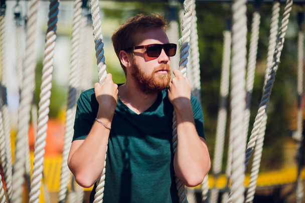 adult man in playground. man with beard and glasses. stylish modern young - Fotoğraf, Görsel