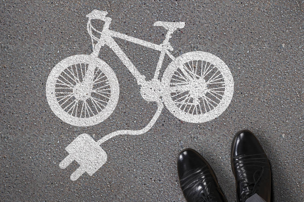Close-up Of Person's Feet Standing Next To Painted Electric Bicycle On Asphalt - Foto, immagini