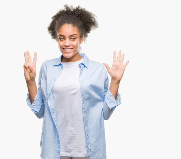 Молодих афро Американку над ізольованих фон показ і вказуючи з пальцями число восьми а посміхаючись впевненими і щасливими. - Фото, зображення