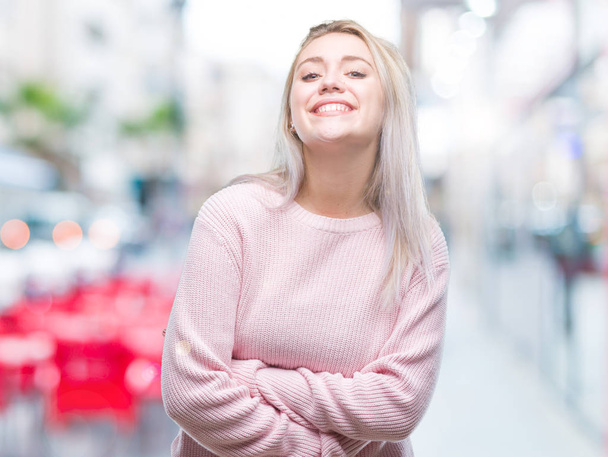 Jeune femme blonde portant un pull d'hiver sur fond isolé heureux visage souriant avec les bras croisés regardant la caméra. Personne positive
. - Photo, image
