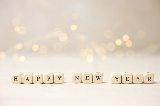 Inscription "Happy New Year" from wooden cubes on festive background. - Foto, Bild