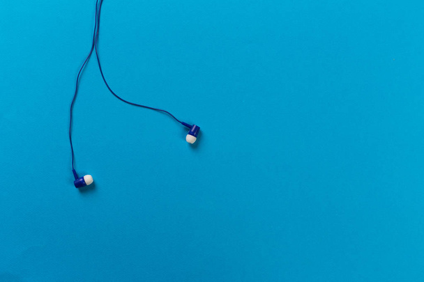 black earphones on blue background - Фото, зображення