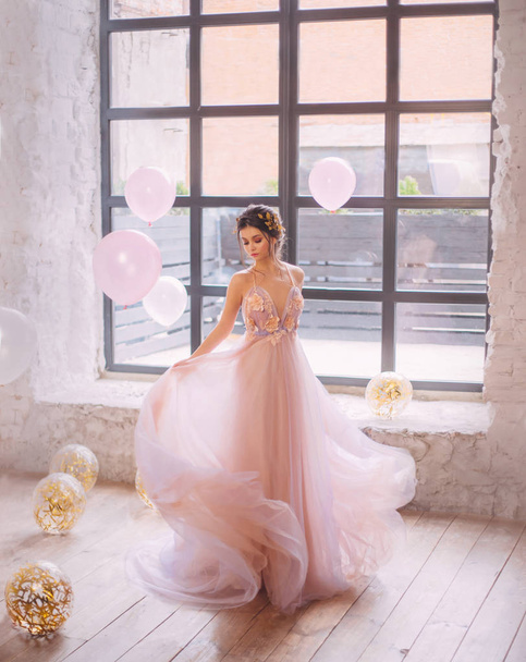 tender girl with a dark hairdo, dancing in a bright room, dressed in a gentle peach with a purple dress with a wavy, flying and fluttering hem, circling. image for prom night, high school graduation. - Foto, Imagem