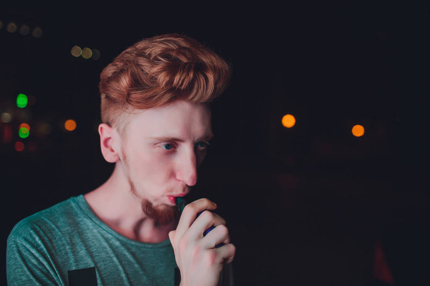 Portrait mature man smoking electronic cigarette in the streets at night - Fotoğraf, Görsel