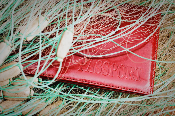 赤いパスポートのクローズ アップは、猟師の網にキャッチ。密猟や違法ちょうざめ釣りとの戦いの概念 - 写真・画像