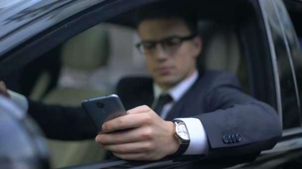 Happy businessman texting with girlfriend and smiling while sitting in car - Footage, Video