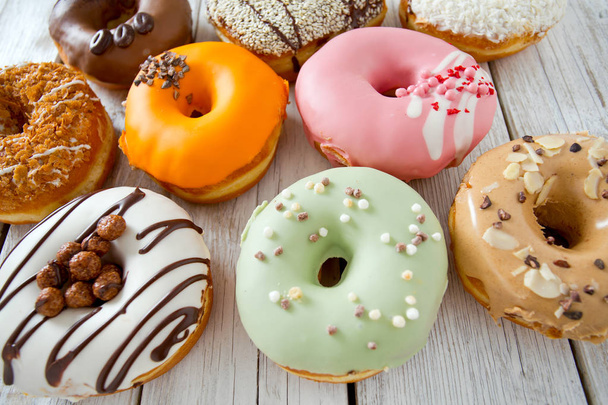 variety of doughnuts on wooden surface - Zdjęcie, obraz