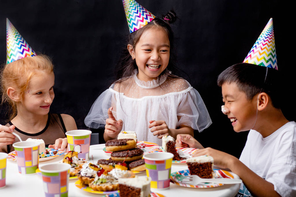 дівчата підробляють на смішному хлопчику з вершками торта на носі
 - Фото, зображення