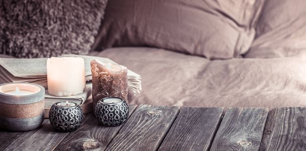 Bodegón acogedor hogar, detalles interiores en la sala de estar en una mesa de madera, el concepto de confort y cuidado del hogar
 - Foto, imagen
