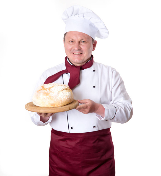 Koken met vers brood in zijn handen op een witte achtergrond. Baker. - Foto, afbeelding