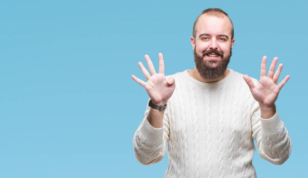 Молодой белый хипстер в зимнем свитере на изолированном фоне показывает и показывает пальцами номер девять улыбаясь уверенно и счастливо
. - Фото, изображение