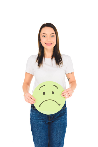 attractive girl holding green sign with sad face expression while looking at camera isolated on white - Foto, Imagem