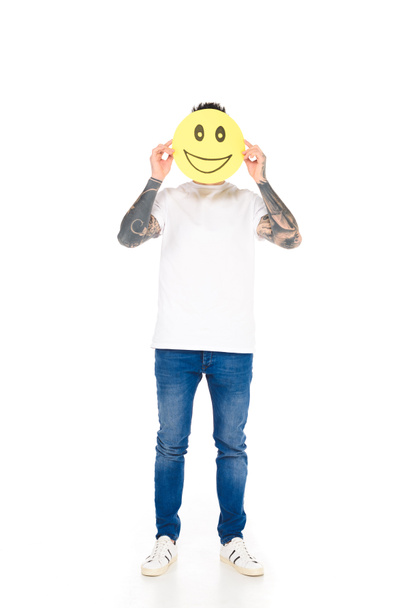 hombre con tatuajes sosteniendo letrero amarillo con expresión de cara feliz aislado en blanco
 - Foto, imagen