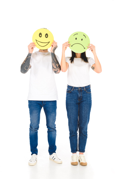 νεαρό ζευγάρι κρατώντας γύρο κάρτες με διαφορετικό πρόσωπο εκφράσεις που απομονώνονται σε λευκό - Φωτογραφία, εικόνα