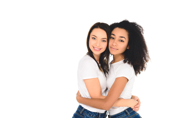 multicultural friends in white T-shirts hugging and looking at camera isolated on white - Photo, Image