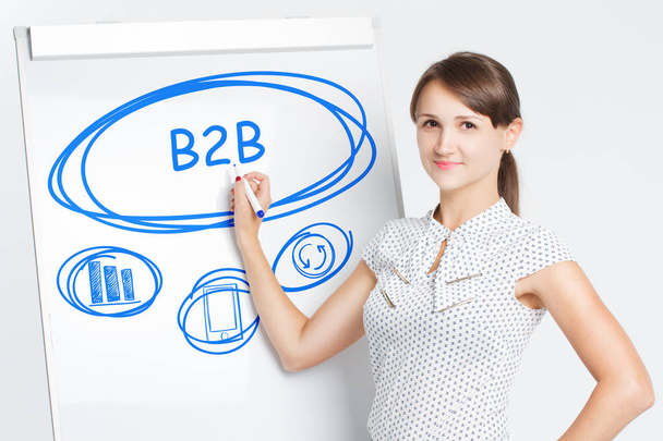 Business, Technology, Internet and network concept. A young entrepreneur writes on the blackboard the word: B2B - Фото, зображення