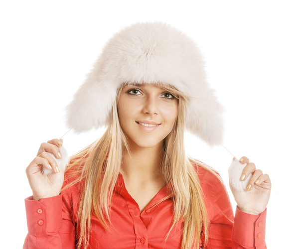 Hermosa joven sonriente en sombrero de piel blanca y camisa roja, aislada sobre fondo blanco
. - Foto, imagen
