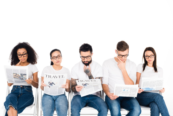 grupo multiétnico de jóvenes en gafas leyendo periódicos aislados en blanco
 - Foto, imagen