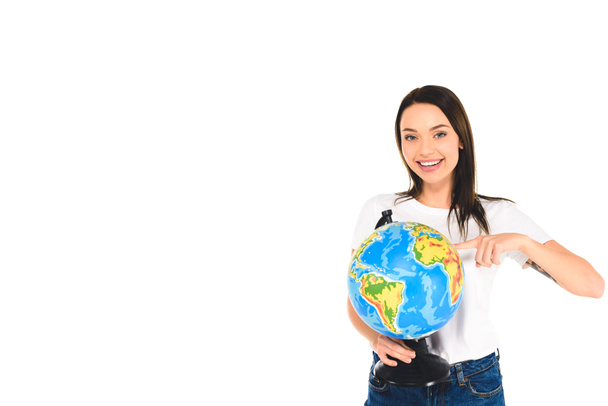 smiling girl pointing with finger at globe isolated on white - Photo, image