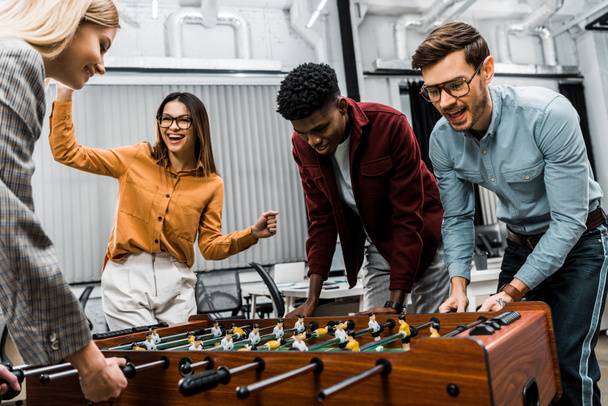 multicultural business colleagues playing table football together in office - Photo, Image