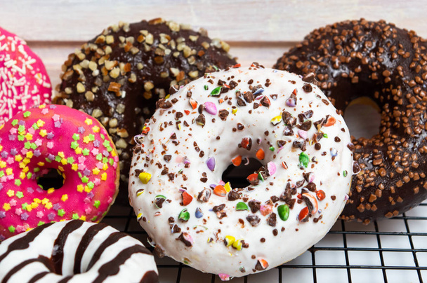 Decorated chocolate donuts on a baking grid top view - Photo, Image