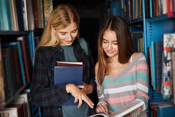 Дві молоді студентки в бібліотеці взули книжки
 - Фото, зображення