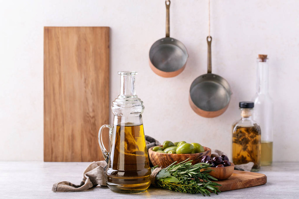 Extra panenský olivový olej, podávané s bylinkami, zelené a černé olivy na šedém pozadí. - Fotografie, Obrázek