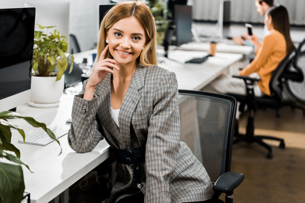 portrait of smiling young businesswoman looking at camera in office - 写真・画像