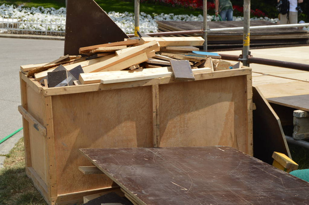 Les déchets de construction en bois se trouvent dans une boîte en bois sur une aire ouverte dans le parc par une journée ensoleillée d'été. - Photo, image