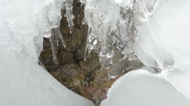 primer plano hielo carámbanos flujo derretir agua gota piedras montaña cueva
 - Metraje, vídeo